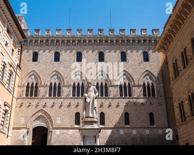 Siena, Italien - August 16 2021: Palazzo Salimbeni, Hauptbüro oder Hauptquartier der Monte dei Paschi Bank, mit Statue von Sallustio Bandini Stockfoto