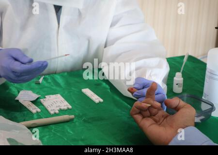 Ein Sanitäter entnimmt einem Patienten Blut für den Schnelltest. Covid-19. SURABAYA, INDONESIEN - 22. Juni 2020 Stockfoto