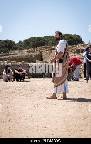 KATALONIEN, SPANIEN-8. MAI 2021: Fremdenführer in authentischer antiker Kleidung bei archäologischen Überresten der antiken Stadt Empuries. Archäologisches Museum von Catal Stockfoto