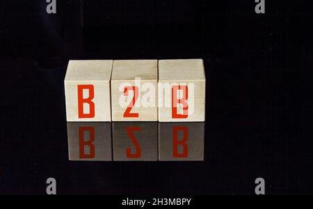 Akronym B2B-Business to Business. Hölzerne kleine Würfel mit Buchstaben auf schwarzem Hintergrund mit Kopie Speicherplatz isoliert. Firmen-Konzept-Image. Stockfoto