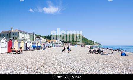 Seaton Devon viele Leute an den Strandhütten am Kieselstrand im Seaton Devon England GB Europa Stockfoto