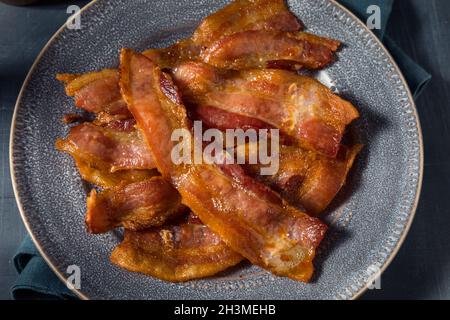 Hausgemachtes fettiges Bacon zum Frühstück auf einem Teller Stockfoto