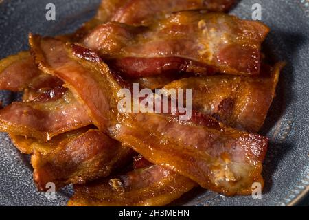 Hausgemachtes fettiges Bacon zum Frühstück auf einem Teller Stockfoto