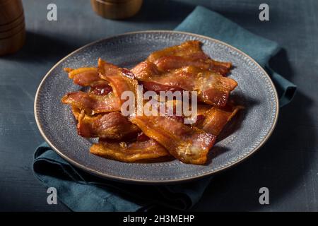 Hausgemachtes fettiges Bacon zum Frühstück auf einem Teller Stockfoto