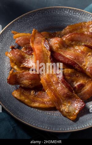 Hausgemachtes fettiges Bacon zum Frühstück auf einem Teller Stockfoto