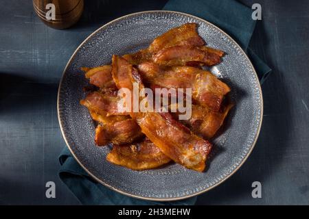 Hausgemachtes fettiges Bacon zum Frühstück auf einem Teller Stockfoto