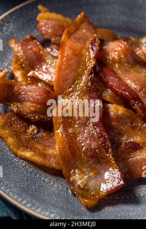 Hausgemachtes fettiges Bacon zum Frühstück auf einem Teller Stockfoto