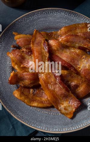 Hausgemachtes fettiges Bacon zum Frühstück auf einem Teller Stockfoto