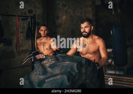 Zwei Freunde machen ein Training mit einem Traktorrad Stockfoto