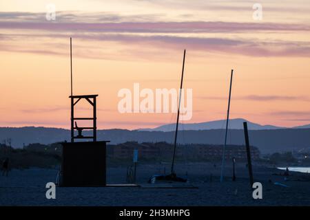 Zellenturm mit Antennen am Strand unter einem bunten Himmel während der Sonnen Stockfoto