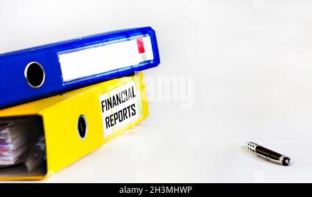 Ein Ordner für Dokumente mit der Aufschrift auf ihm Finanzbericht, auf weißem Hintergrund mit einem Stift. Ort zum Schreiben Stockfoto
