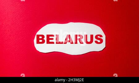 Weißrussland, Wort geschrieben auf einem weißen Stück Papier und einem roten Hintergrund Stockfoto