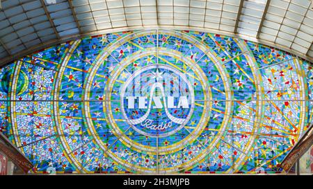 Glasfenster mit Tesla Radio Logo: Das Logo für Tesla Radio ziert eine Einkaufspassage in Prag. Stockfoto