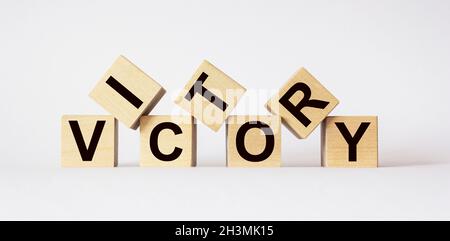 Sieg, Text auf Holzwürfeln auf hellem Hintergrund Stockfoto