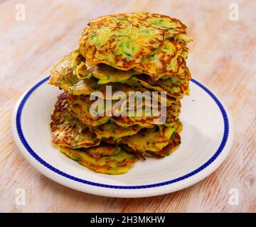 Zucchini-Krapfen auf dem Teller Stockfoto