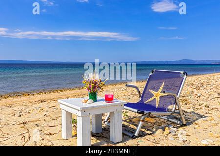 Blumenstrauß, Getränk und seestern am Strand Stockfoto