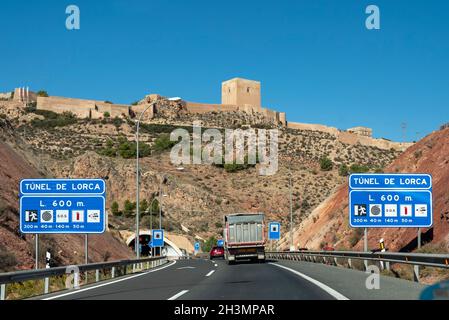 Burg von Lorca, oberhalb des Straßentunnels A-7 in Lorca, Region Murcia, Spanien. Historisches Castillo de Lorca Wahrzeichen hoch über der Autobahnausfahrt Stockfoto