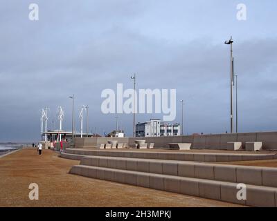 Menschen auf der Promenade entlang der Küste bei cleveleys in blackpool mit Stufen, die zum Strand und Cafe am Ende des führen Stockfoto