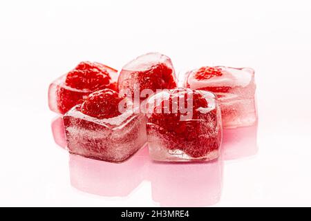 Himbeer-Eiswürfel auf rosa glänzenden Hintergrund Stockfoto