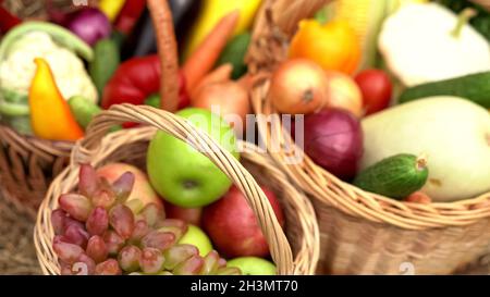 Sommer Obst und Gemüse in Körben. Abstraktes unscharfes Bild mit Äpfeln, Trauben, Blumenkohl, Karotten, Auberginen, Paprika, auf Stockfoto