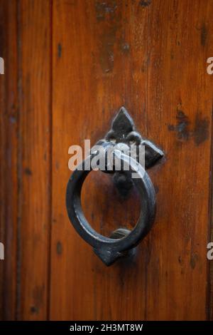 Vintage-Griff an hölzerner Eingangstür. Türknauf aus antikem Metall, kreisförmig an der braunen Vordertür. Nahaufnahme Stockfoto