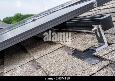 Schiene, Halterung und Anker an einem Solarpanel, das auf einem Asphaltschindeldach installiert ist Stockfoto