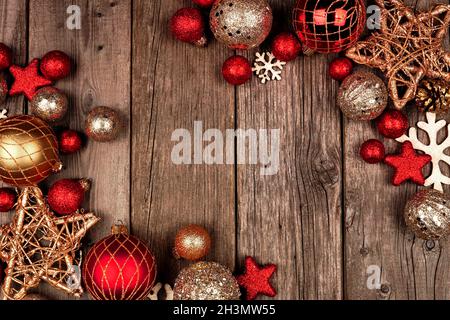 Rot und Gold Weihnachten Ornament doppelte Eckumrandung. Blick von oben auf einem rustikalen Holzhintergrund. Stockfoto