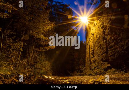 Eine Straßenlampe beleuchtet eine Landstraße in der Dämmerung Stockfoto