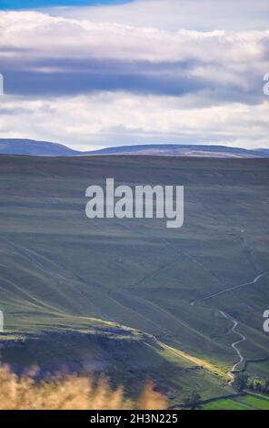 Panoramablick von oben Kettlewell im Yorkshire Dales National Park mit steiler Cam Gill Road in der Ferne, Wharfedale, North Yorkshire, England Stockfoto