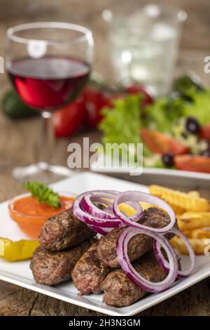 Cevapcici auf dem Teller auf Holz Stockfoto