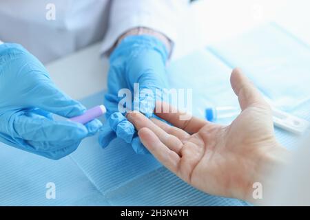 Behandelter Arzt führt einen Bluttest mit Lanzette von einem Patienten in der Klinik durch Stockfoto