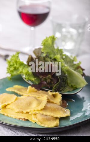 Ravioli mit Sahnesauce und Salat Stockfoto