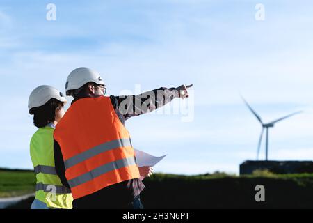 Mitarbeiter für nachhaltige Energie - Ingenieure, die im Windpark für erneuerbare Energien arbeiten Stockfoto