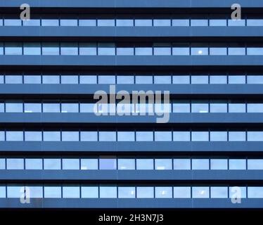 Vollformatbild eines großen Geschäftsgebäudes mit sich wiederholenden Reihen geometrischer Fenster Stockfoto
