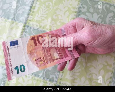 Alte Frau bezahlt mit einem Geldschein Stockfoto