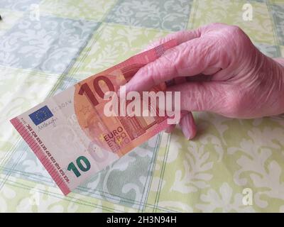 Alte Frau bezahlt mit einem Geldschein Stockfoto