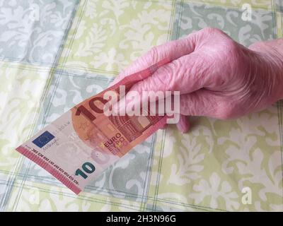 Alte Frau bezahlt mit einem Geldschein Stockfoto