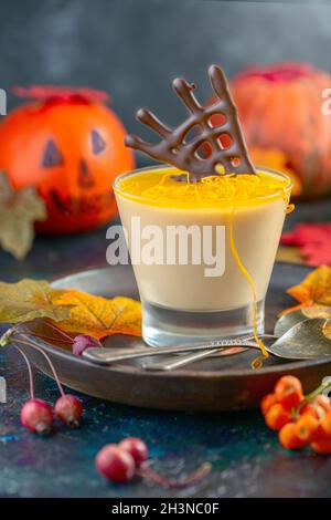 Kürbis-Panna-Cotta mit orangefarbenem Gelee und Schokoladendekor. Stockfoto