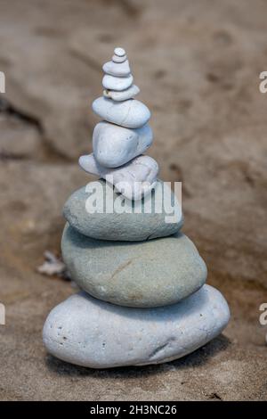 Kieselsteine in einer Turmformation an einem Strand in griechenland ausgeglichen, Kieselsteine oder Felsen im Stapel balancieren eins auf dem anderen, um einen Turm aus Steinen zu bilden. Stockfoto
