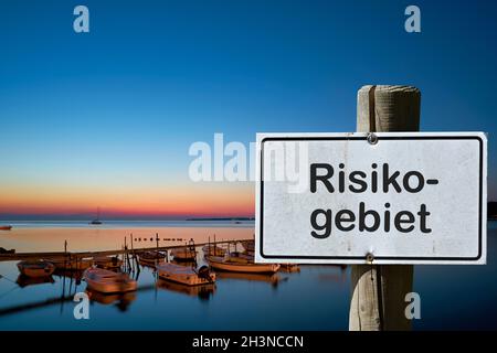 Schild mit der Aufschrift Risikobereich (Risikogebiet). Aufgrund vieler neuer Corona-Infektionen sind Bereiche d Stockfoto