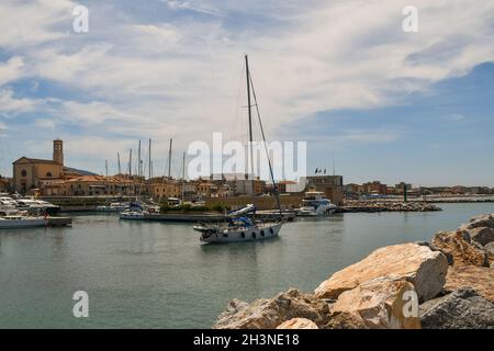 Ein Segelboot, das im Sommer aus dem Touristenhafen des Fischerdorfes kommt, San Vincenzo, Livorno, Toskana, Italien Stockfoto