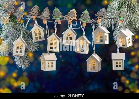 Weihnachtsgirlande aus Lichtern in Form von weißen Häusern. Stockfoto