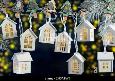 Weihnachtsgirlande aus Lichtern in Form von weißen Häusern. Stockfoto