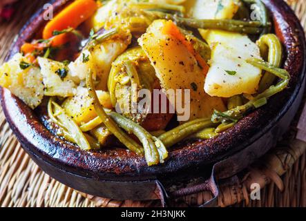 Tajine oder Tagine: Traditionelle berberische Gerichte, die in einer Steingutschüssel in einem typisch marokkanischen Straßenrestaurant serviert werden, Nahaufnahme Stockfoto