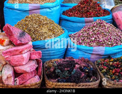 Stapel getrockneter Rosen und anderer Blumen, die als natürliche Düfte verwendet werden, werden auf dem Souk - dem traditionellen Straßenmarkt in Marokko - präsentiert Stockfoto