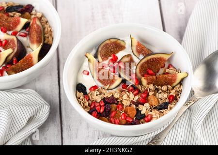 Gesundes und leckeres Frühstück. Haferflocken-Müsli mit griechischem Joghurt, frischen Feigen, getrockneten Früchten und Pome Stockfoto