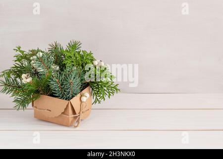 Weihnachtliche Dekoration in weiß und grün, weihnachtlicher Tannenstrauß auf weißem Tisch, Kopierraum. Hochwertige Fotos Stockfotografie