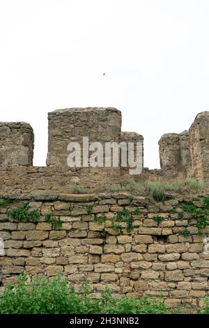 Die Festungsmauer besteht aus Naturstein. Uralter Kalkstein. Kreativer Vintage-Hintergrund. Ukraine. Belgorod - Dnestrovsky. Stockfoto