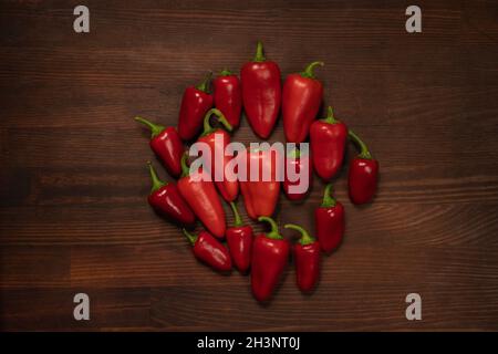 Ein paar Paprika und Paprika oder Paprika. Süße Glocke, Paprika, Cayenne, ungarischer Wachspeffer, isoliert auf Holztisch-Bac Stockfoto