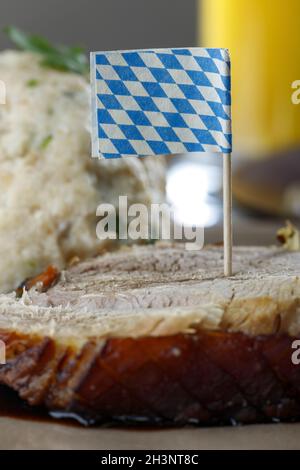 Bayerischer Schweinebraten auf dunklem Holz Stockfoto